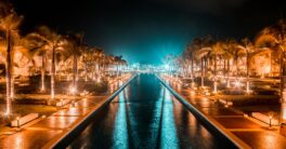 a view of a waterway at night with palm trees