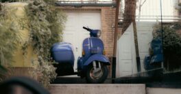 a blue scooter parked in front of a house