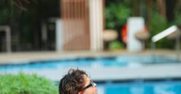 a man sitting on the edge of a swimming pool